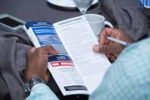 CICA 2018 International Conference attendee holding printed onsite program of events while holding pen