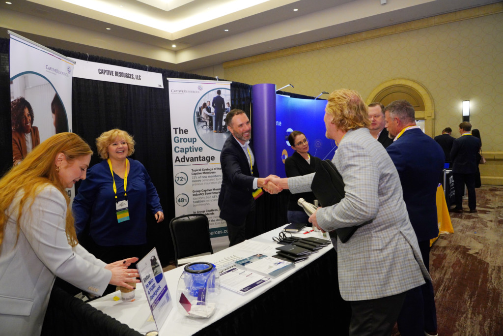 CICA 2023 International Conference exhibitor shakes hands with attendee smiling