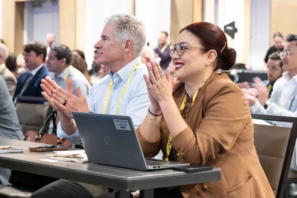 An attendee smiles and claps during an education session at the CICA 2026 International Conference